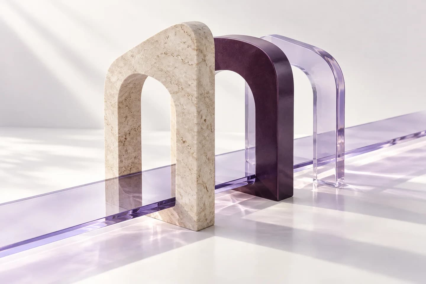 Drei aufeinander abgestimmte Bögen aus hellem Stein und violettem Glas, verbunden durch einen gemeinsamen Weg.